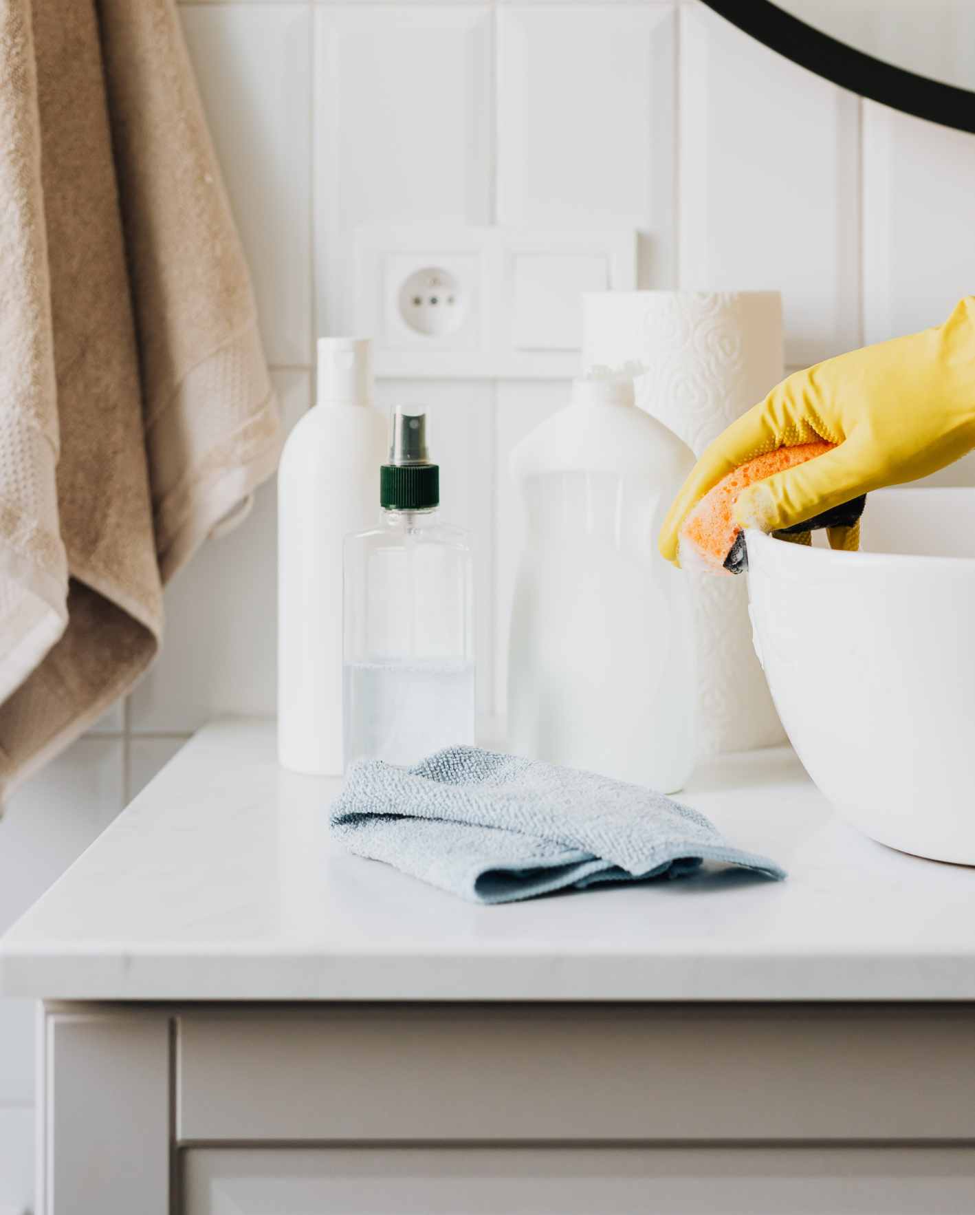 A close-up of professional cleaning supplies and gloves in a bright bathroom, highlighting how Park Place Properties helps Miami Airbnb owners maintain spotless, guest-ready rentals between every stay.