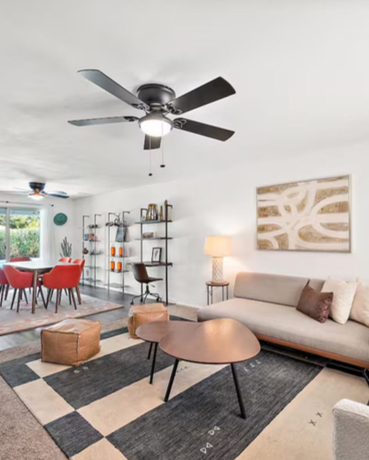Modern Orlando Airbnb living room with neutral sofa, ceiling fan, dining area, and staged interior design.