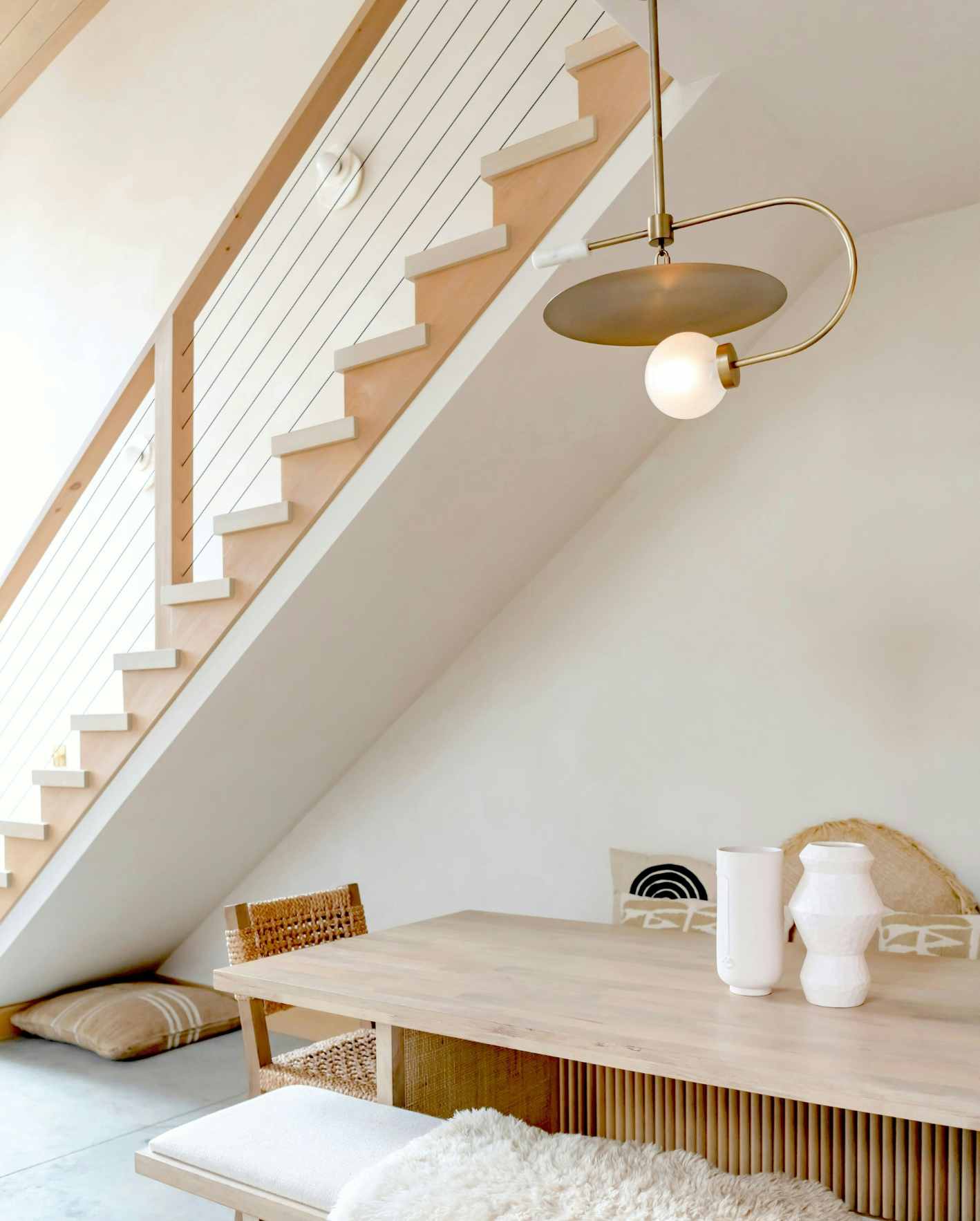 Stylish Scottsdale Airbnb dining area with modern staircase, wood table, and guest-ready interior design.