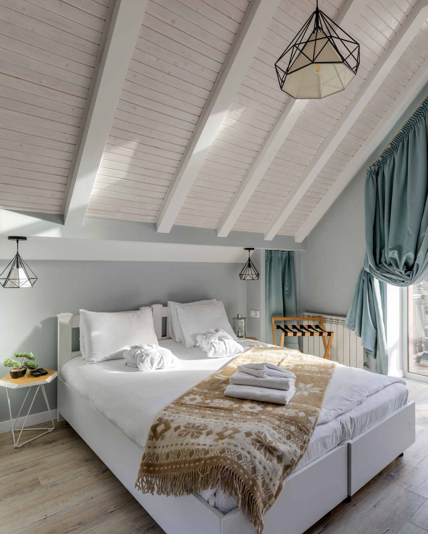 A bright, professionally staged short-term rental bedroom with fresh linens, folded towels, and polished design details, showing how Park Place Properties helps owners improve guest appeal and listing performance.